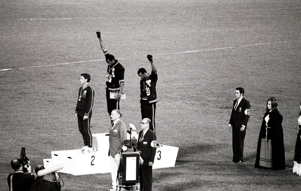 Jeux olympiques de Mexico. Podium du 200 mètres masculin, de g. à dr. : Peter Norman (Australie, 2ème), Tommie Smith et John Carlos (Etats-Unis, respectivement 1er et 3ème, faisant le signe du "Black Power"), 16 octobre 1968.