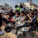 Palestinian people displaced from their homes wait for food at Al-Shaboura Camp, in the centre of Rafa, Gaza, in December 2023. | Credit: WHO